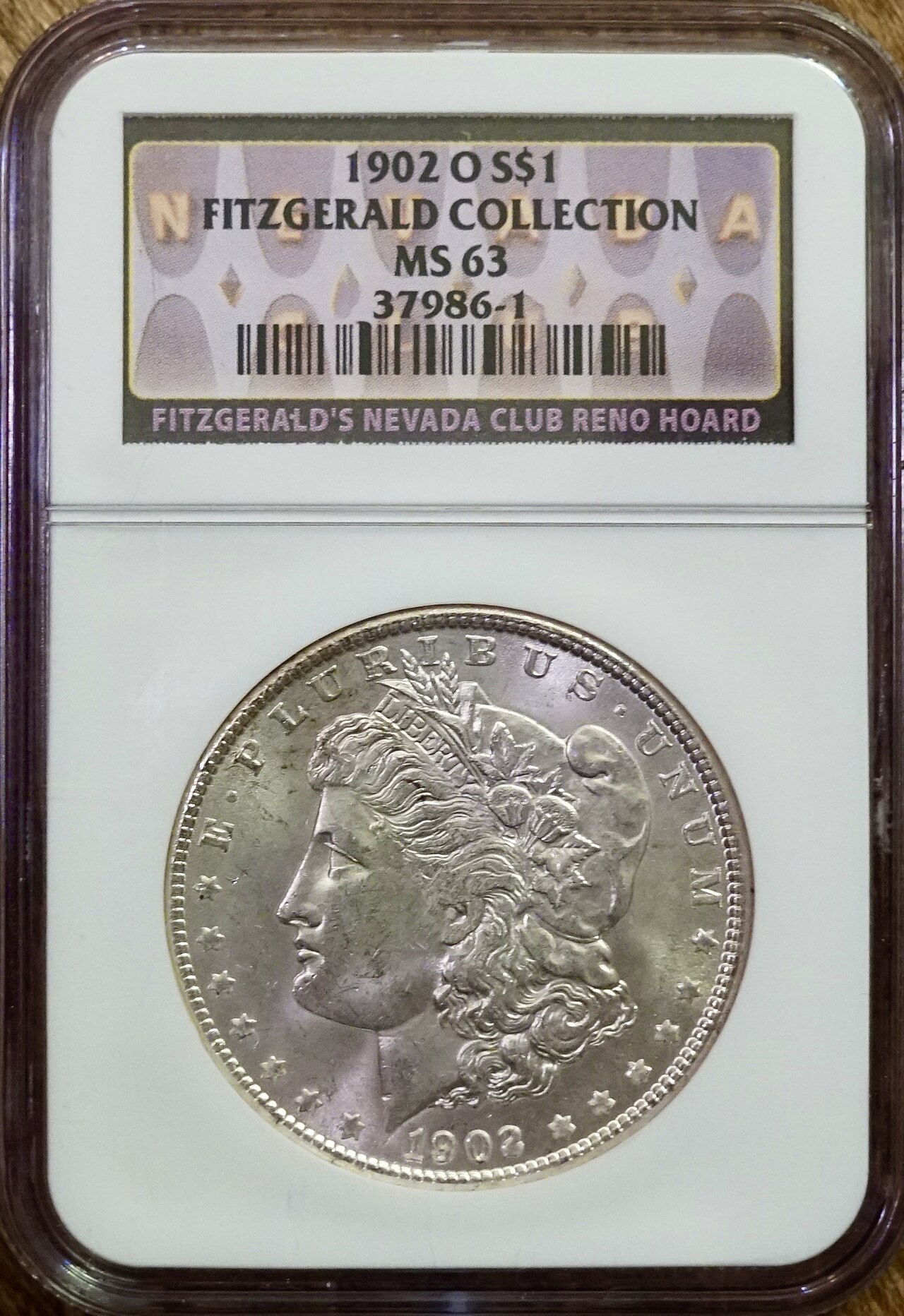 A 1902-O Morgan dollar graded NGC MS-63 in its holder, showing scattered contact marks on the cheek