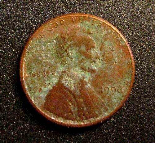 Lincoln cent covered in green verdigris corrosion